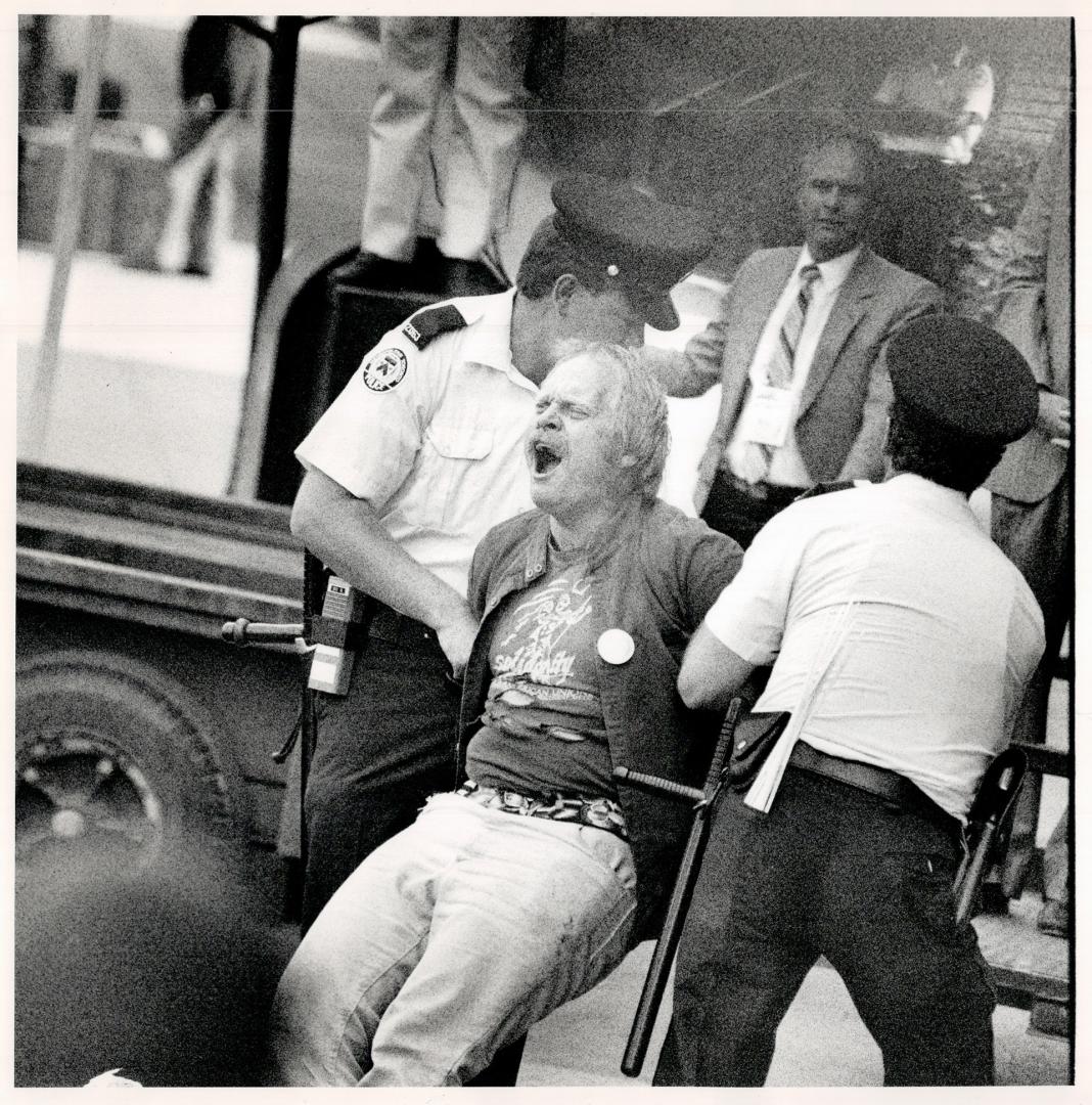 Summit protesters: A demonstrator howls in protest, above, as he is hauled away by police