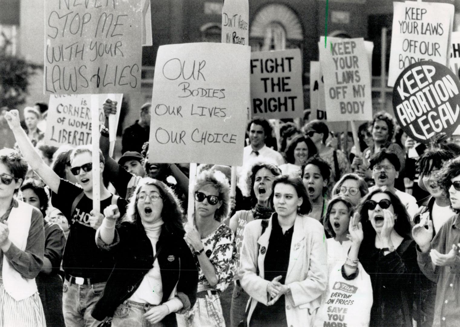 Showing solidarity: Several hundred pro-choice supporters raise banners yesterday urging the federal government not to introduce laws restricting abortion