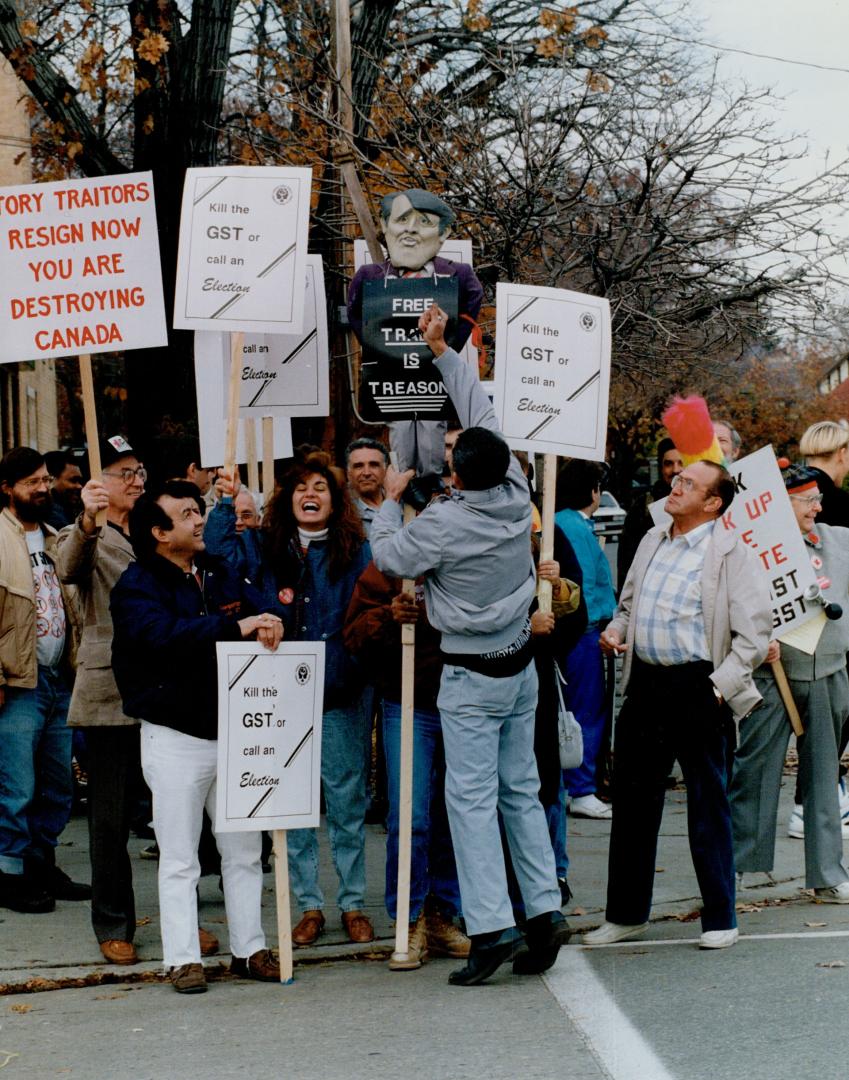 Tax protest: A demonstrator attacks an effigy of Prime Minister Brian Mulroney at a protest against the GST yesterday at the offices of Finance Minster Michael Wilson