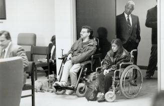 Waiting game: A security guard watches at a Metro committee meeting yesterday as protesters - many in wheelchairs - fight planned funding cuts