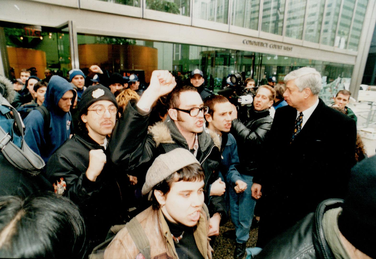 It's over: Toronto Police Chief David Boothby watches yesterday morning as protesters pour out of CIBC lobby at Bay and King Sts