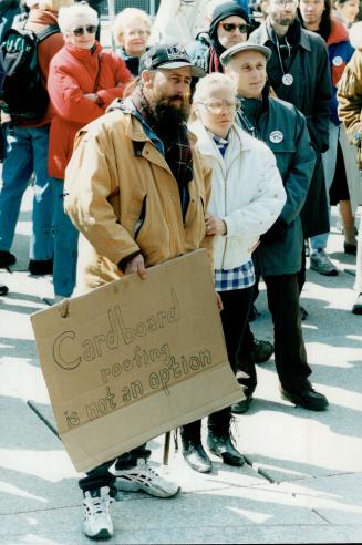 Housing issue: A man holds a sign at a rally to support the homeless outside city hall yesterday