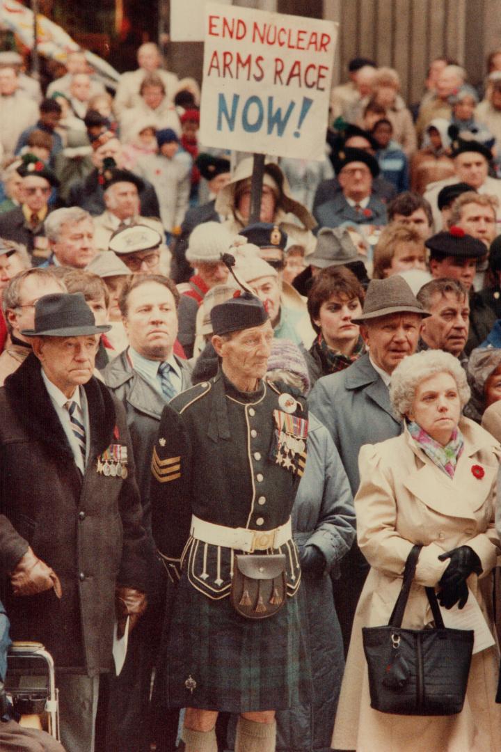 Voice for peace: As others recalled past wars, a person bearing an anti-nuclear sign focused on the threat of future wars yesterday at Remembrance Day ceremonies at old city hall