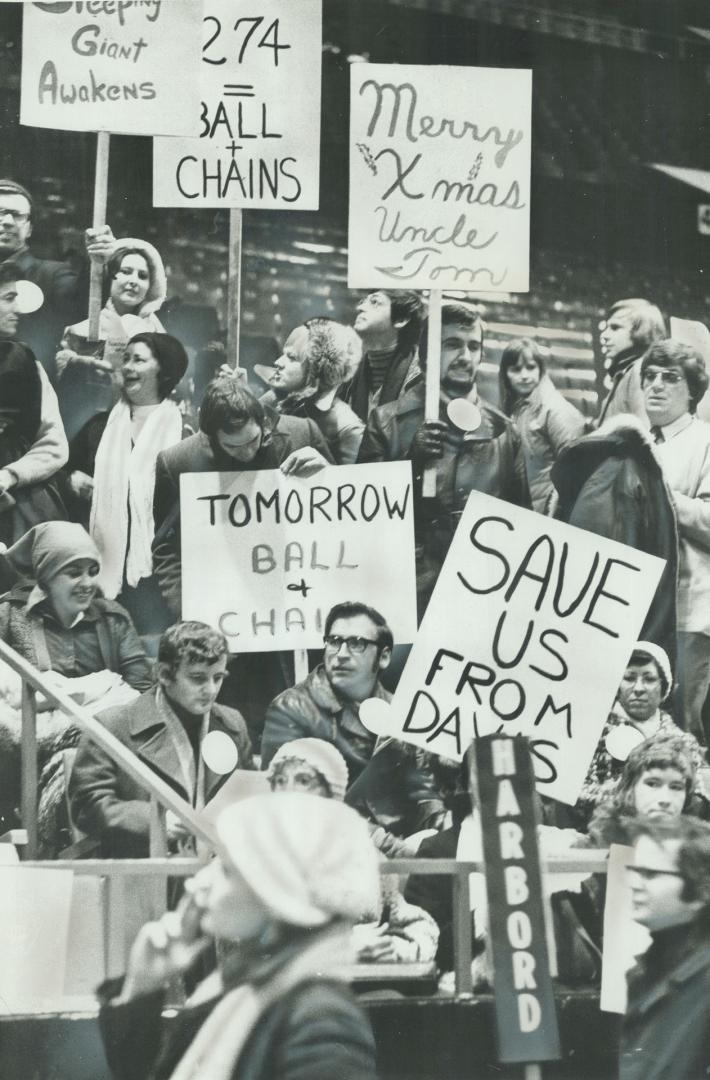 Demonstrating Teachers hold signs aloft in Maple Leaf Gardens today, ready to cary them in a march across College St