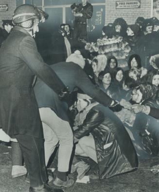 A woman chained to other militant feminists is grabbed by a Montreal policeman during a protest last night against the city's anti-demonstration bylaw(...)