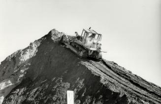 On top of a sandy summit, Building mountains, out of sand, is all in a day's work for the driver of this bulldozer at Franceschini Brothers Aggregates(...)