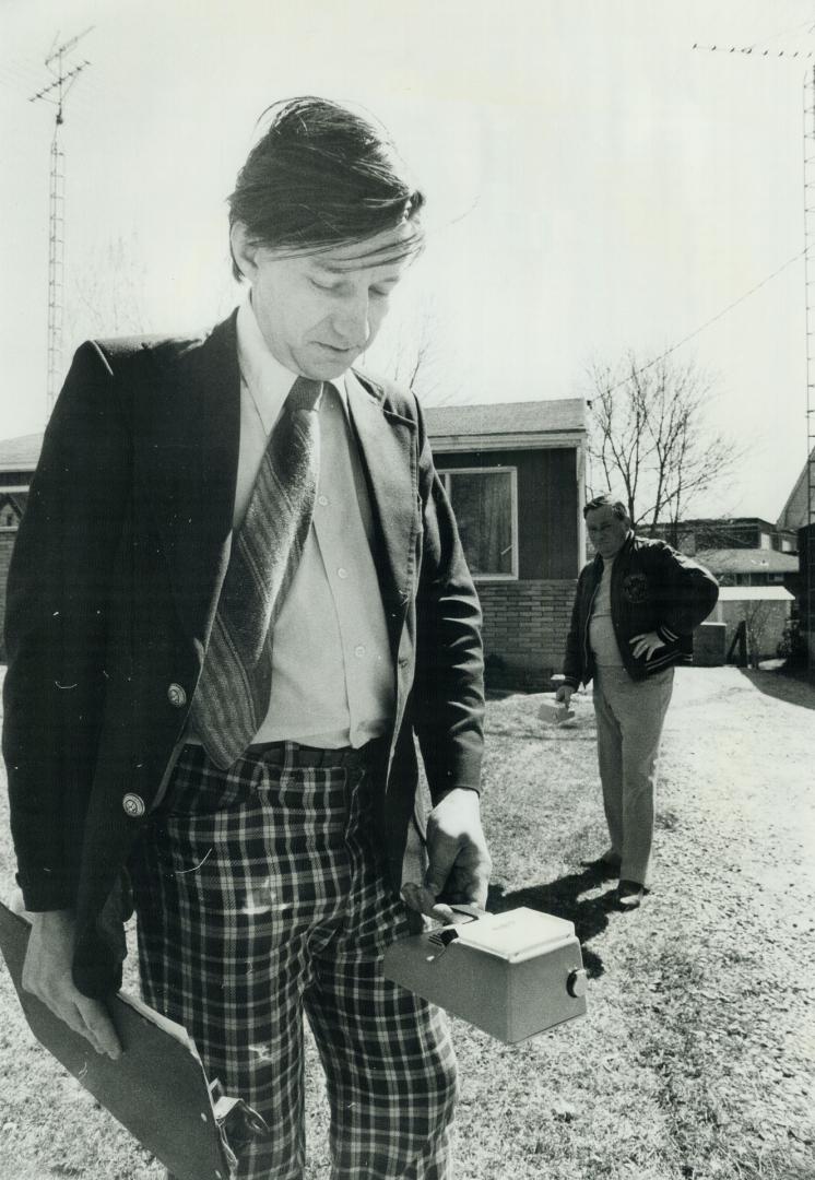 6. Eric Draper in foreground and Gerald Gibson taking readings around house on Yonge St. in Port Hope