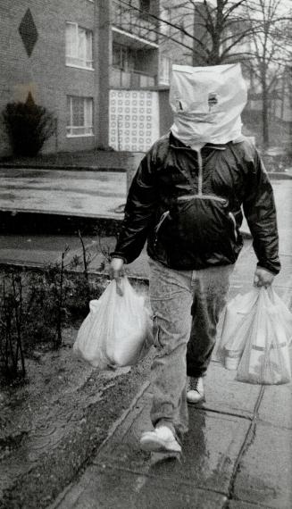 Keeping Dry: Pat Shea beat the rain yesterday by donning a grocery bag after doing some weekend shopping