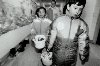 Viviane Sotoya and Tony DeBono carry palls of waste for the composters