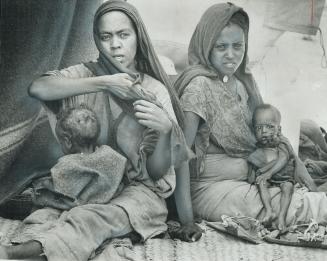 Holding sick children, mothers wait for medical attention in a refugee camp at Arabati, in the highlands of Ethiopia