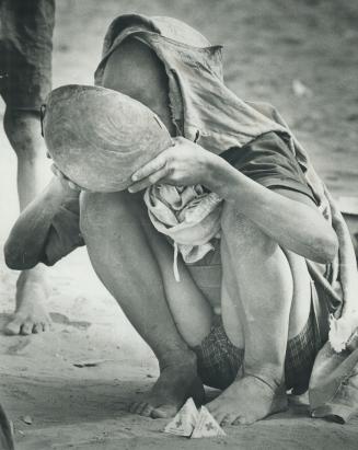 Milk from Canada is good to the last lick for a hungry boy at a refugee camp in central Niger, Africa