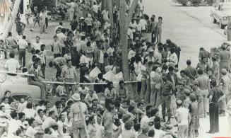 Crowds of refugees wait because there was a shortage of buses to take them to Immigration hearings