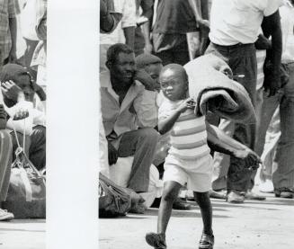 Back in hell: A young returned refugee disembarks in Port-au-Prince