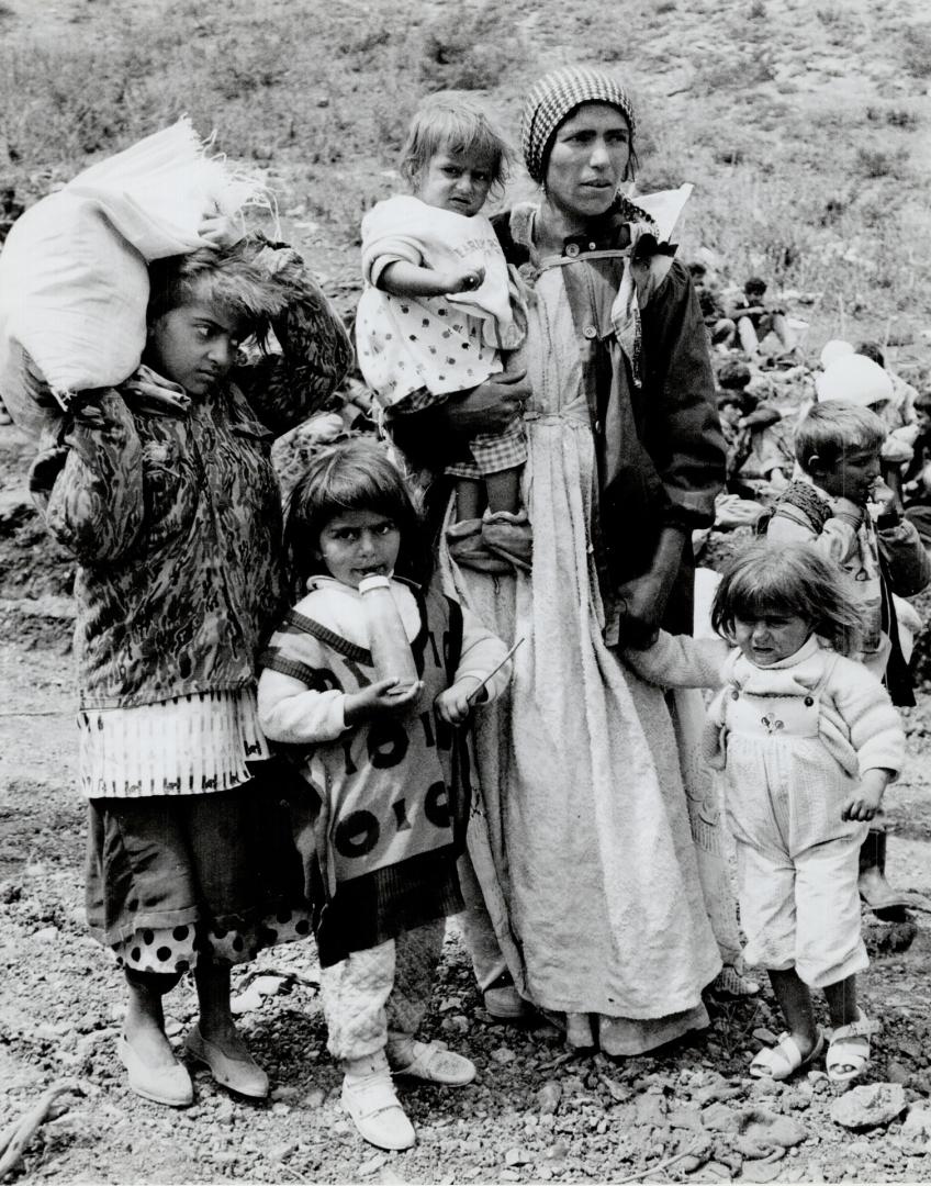 Water lineup: Refugees, left, have to line up for everything at the camps but still more and more families in daily, above