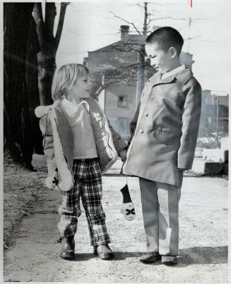 A cobourg girl greets Tibetan boy, Jennifer Radley, with friend Tenpa Gyelzan