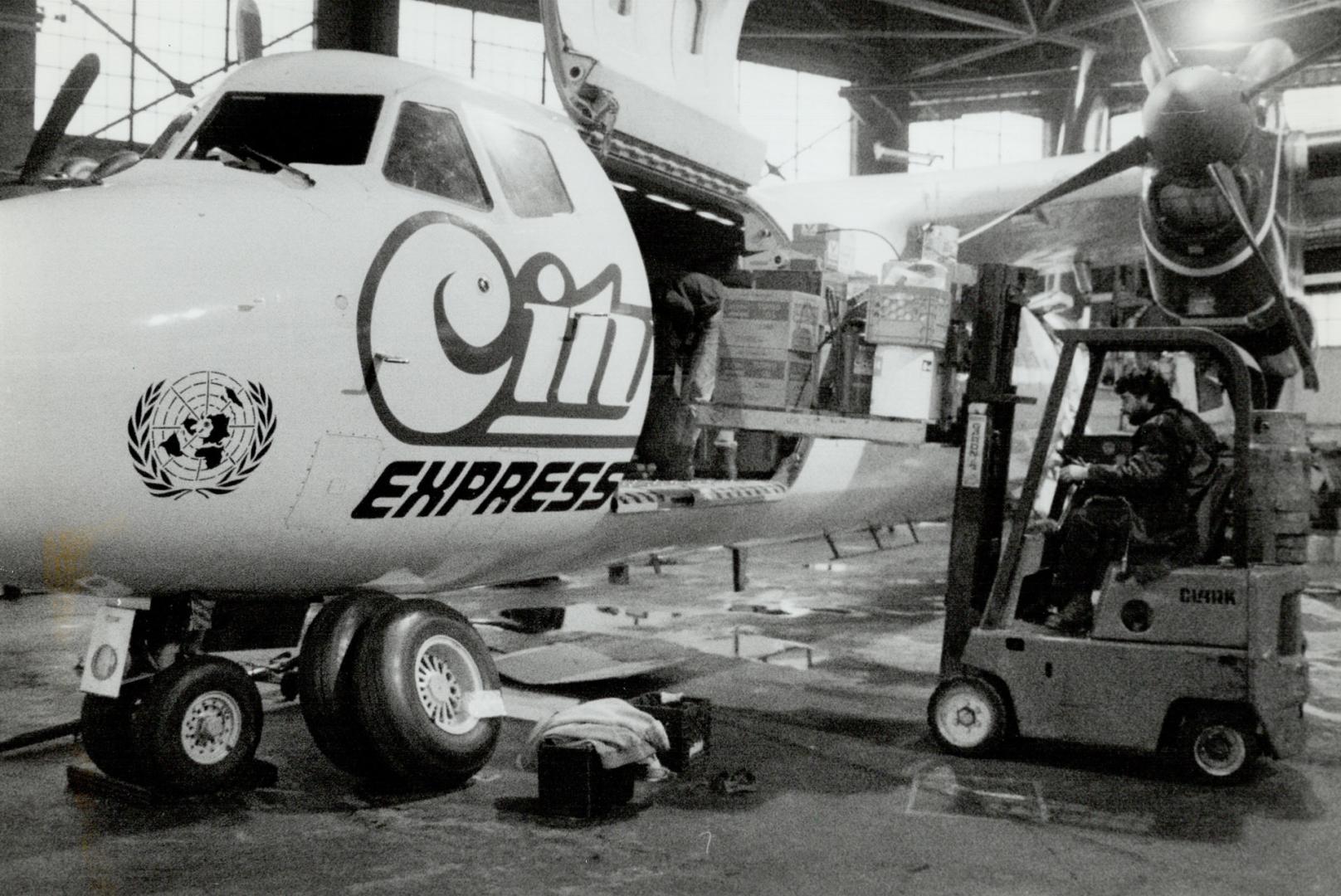 Famine Relief On Way To Sudan, An Island Airport employee loads a specially marked de Havilland Dash 7 before it left Toronto yesterday for the Sudan (...)