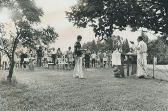 Preaching an outdoor mass, Father Benoit Jobin leads the parishioners of St