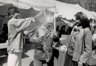 Hindu spring festival, Hermant Misir, left, and Raj Persaud sprinkle scented, colored powder on Cyril Doobay as part of the Festival of Colors at Vish(...)