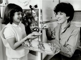 Tracy Wise, 8, helps mother Lynda prepare special chocolate roll for Passover dessert