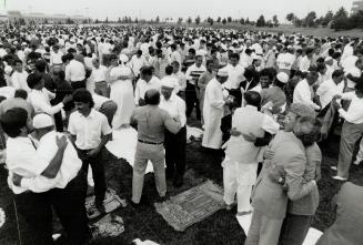 Holy Day: About 6,000 members of Metro's Muslim community hug each other in a greeting yesterday in Markham where they gathered to mark the end of Haj rituals in Saudi Arabia