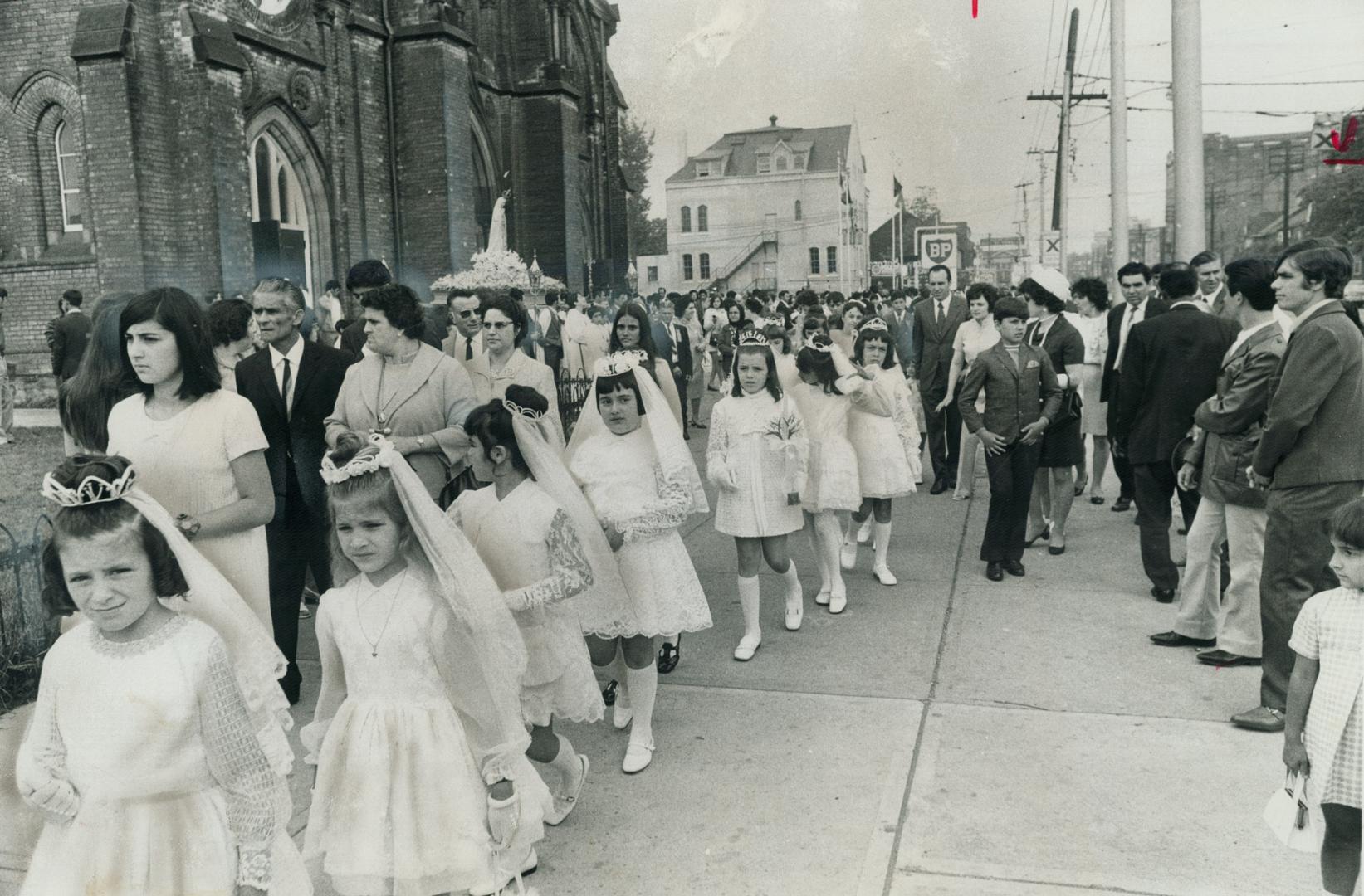 Metro's Portuguese hold a parade, Winding up Toronto's officially-proclaimed Week of Portugal, a group of young girls walk in front of a statue of Our(...)