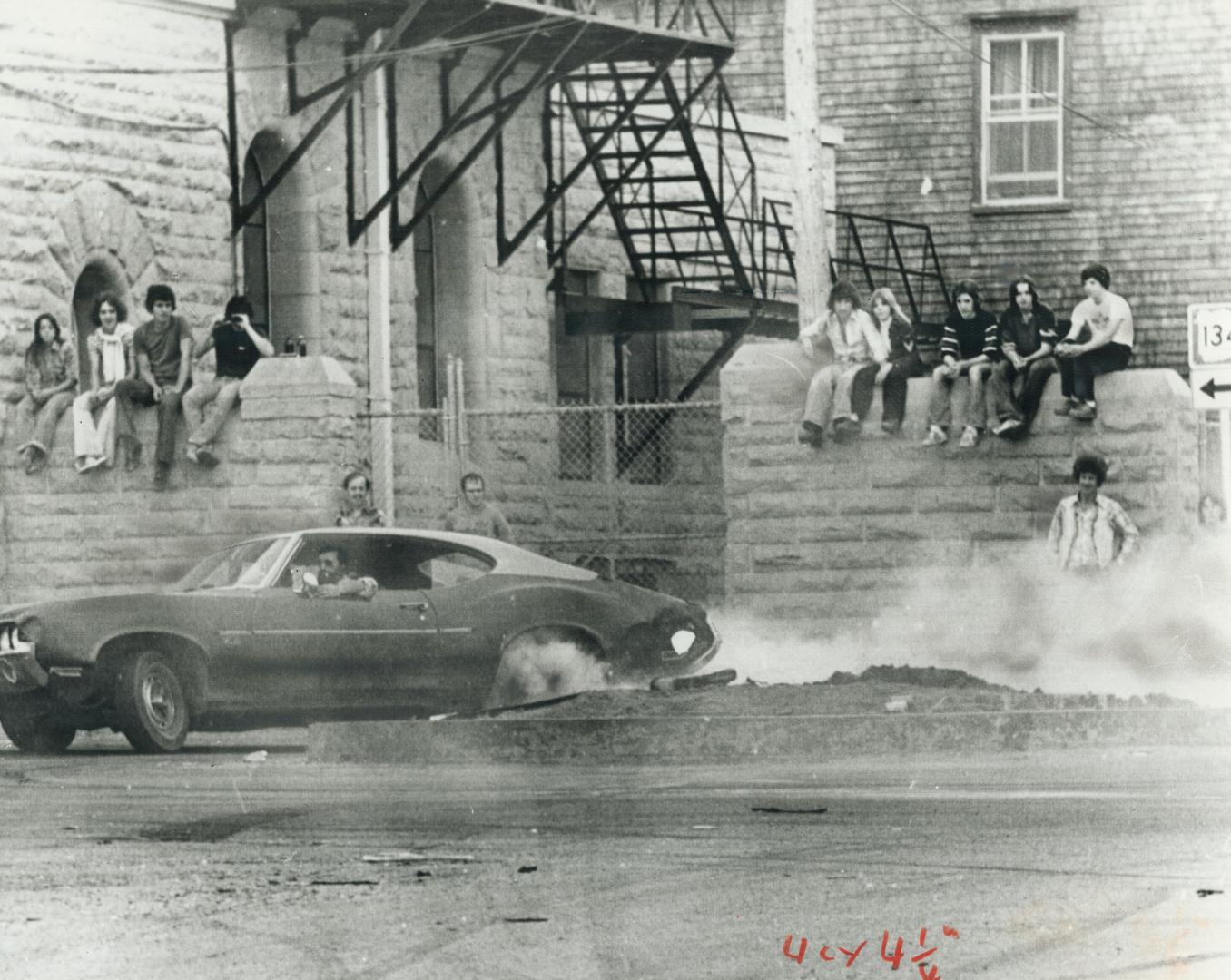 Crowd looks on as driver turns Bathurst streets into a drag strip, filling downtown with the smell of burning rubber