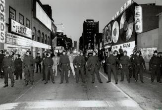 A line of Metro police officers supported by others on horseback blocks off Yonge St