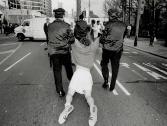 Metro police drag away a suspect during Monday's looting and rioting