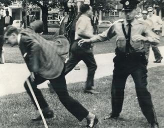 Der Fuehrer gets His Lumps -- Then Jail, Canadian Nazi Party leader John Beattie takes off at the dead run (left) after his second demonstration at Al(...)