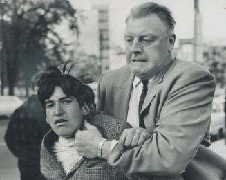 Inspector James Henderson gets an arm-hold on a youth at scene of fracas