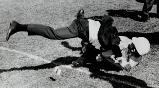 Down they go: Fan and policeman hit the ground and it's still not certain at this point who will come out on top, although there's a firm headlock on fan