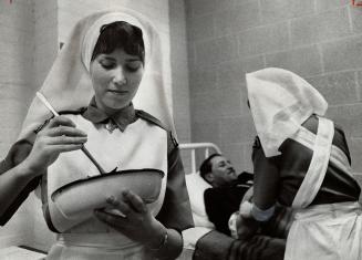 St. John Ambulance members working on a Victim played by male model, Demonstrating the society's usefulness here are Maureen Lennon (left) and Lesley Foxwell