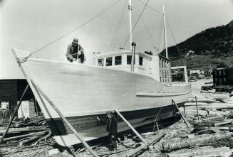 Fishermen put finishing touches on a long-liner shore fishing ship (20 tons) they have built themselfs (4) in salvage