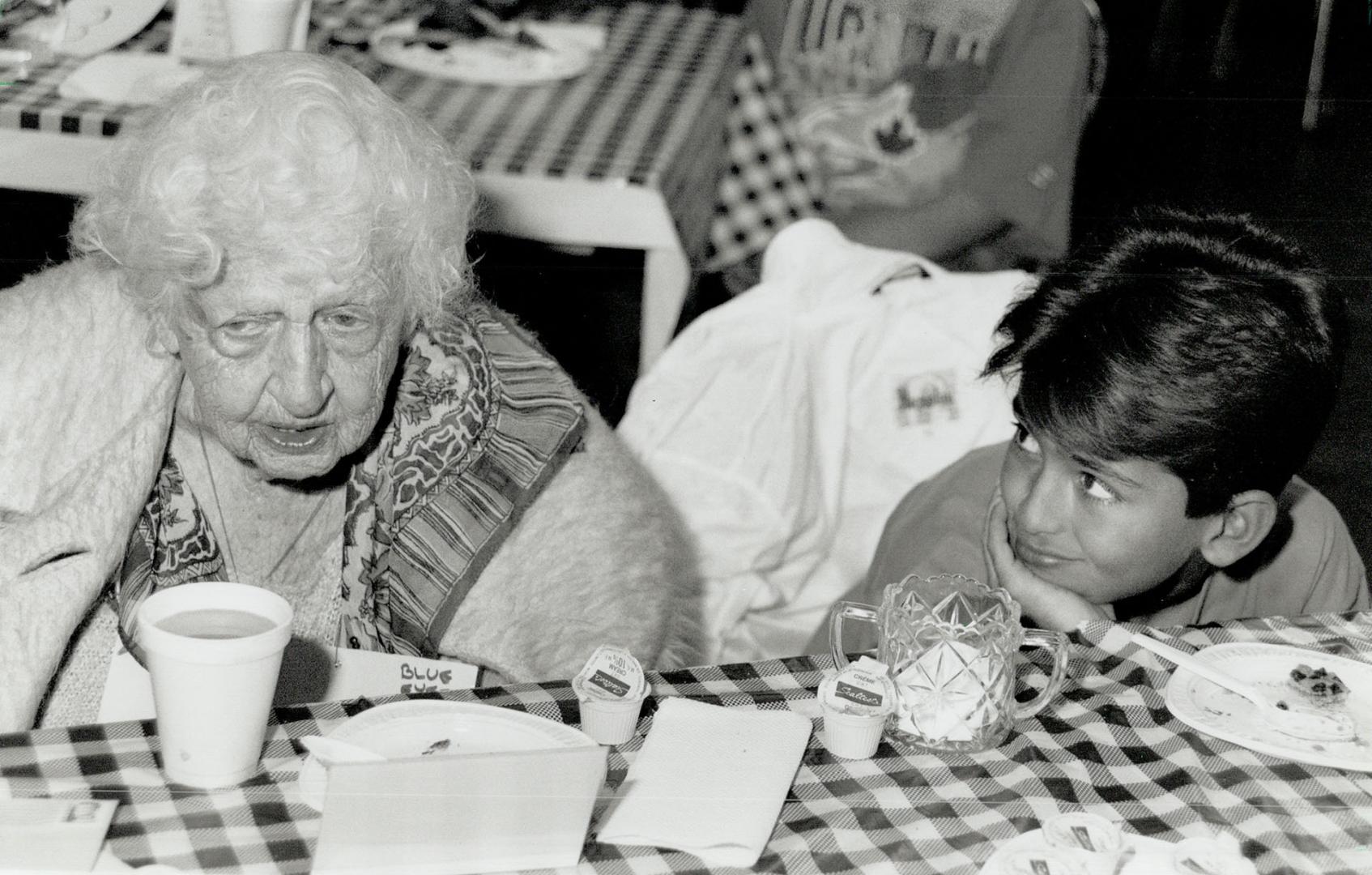 Tea for two: Amir Khadivi, 11, listens to pen pal violet spradborw, 91, yesterday at pleasant Avenue public School, where they were among the pairs to meet after exchanging letters