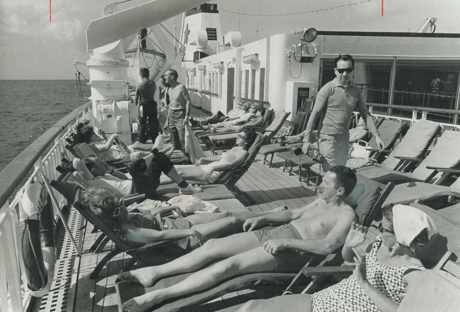 Dockside bargaining for souvenirs is one of the standard pastimes for cruise passengers, though these two don't appear to like the prices. At right a happier group enjoys a day afloat in the sun