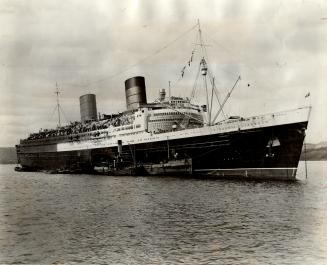 Facial for the giant liner Queen Elizabeth requires 30 tons of black and red paint to change her wartime mistgray to her peacetime colors at Southampt(...)