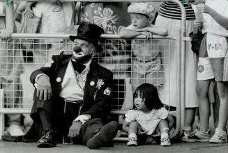 Best seats: Kurt Menzefricke, 4, and Atsuko Kikuchi, 2, join clown Bill Benz to watch the final Shriners' Parade