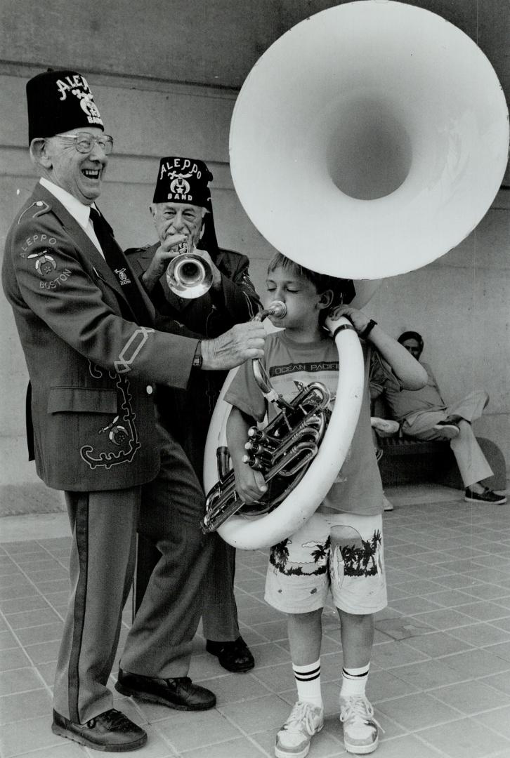 Jeffrey Woodham, right, toots with Ernest Sears, left, and Morris Solov