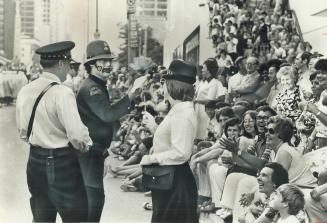 Clown presents flowers to Metro police officer during Shrine parade, above