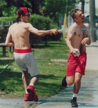 Bill Marks, 15, gets a quick cooling down after working up a sweat while doing the spring gardening chores at his home on Finch Ave. W. Bill's friend,(...)