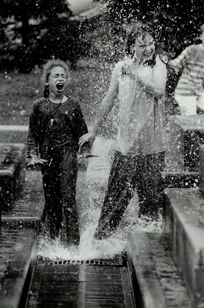 Making a big splash, Nine-year-old Sheri Barton, left, and 11-year-old Susie Prince take advantage of a warm, sunny day, screaming with delight as the(...)