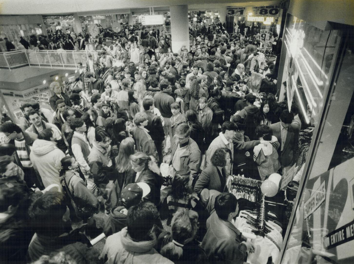 Throngs of serious bargain-hunters armed with credit cards and Christmas cash invade the Eaton Centre yesterday on a mission to seek and purchase marked-down shoes, electronics and leather jackets