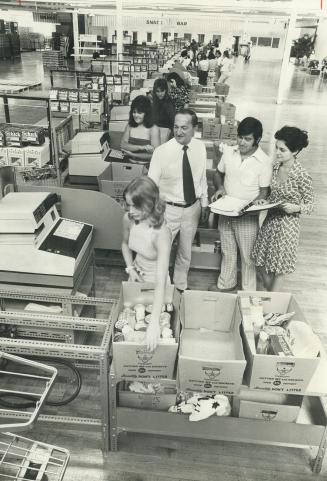 Surrounded by cashier trainees, Steve Stavro looks over his newest food store at Lansdowne and Dundas