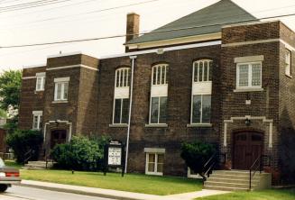 Image shows a church building with a few street entrances. 