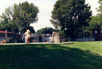 Image shows a playground with some trees in the background.