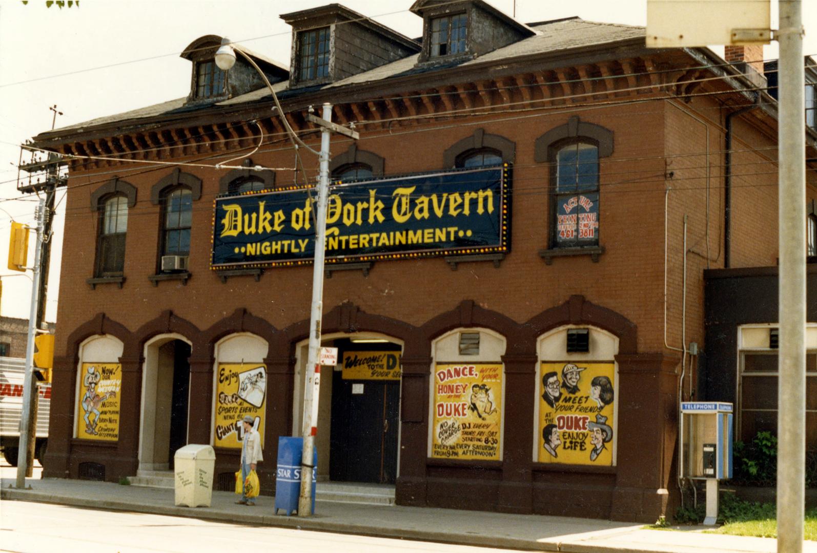 Image shows a two storey building facing the street with a sign that reads|: "Duke of York Tave…