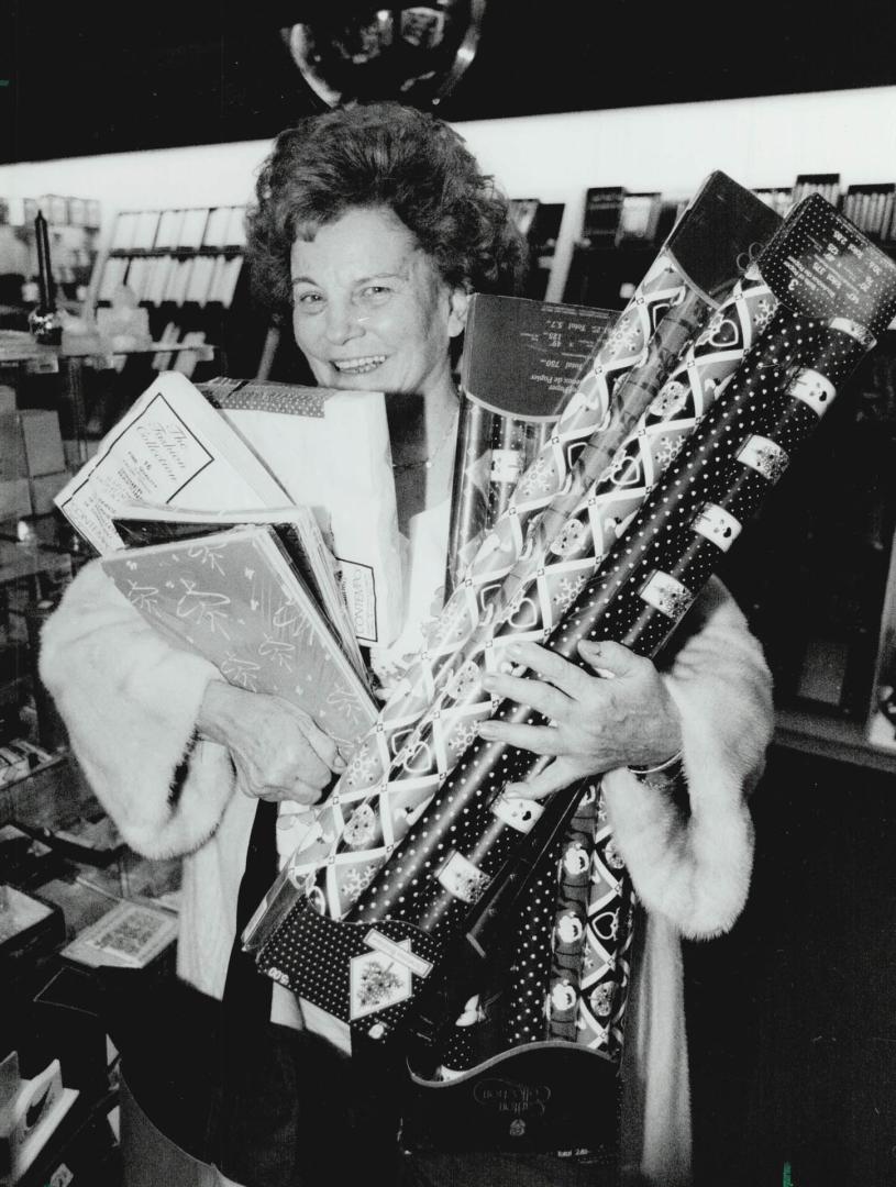 Jeanie Hersenhoren scoops up cut-price Christmas wrap as she joins Boxing Day bargain hunters at the Eaton Centre today