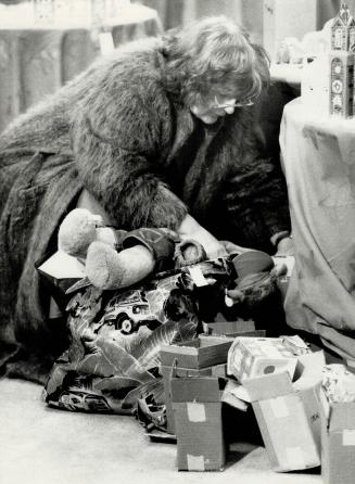 Battle position: A shopper kneels on the floor as she searches through toys and small items at the downtown Simpsons store, which is usually closed on a Sunday