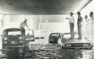 Waiting for help, Bill McLachlan and George Hawkins (right), of Orangeville, stand on car under Yonge St