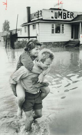 Lumber Worker Piotr Grzyb of Woodbine Building Materials carries manager's wife, Zofia Kepinski, out of the building on Woodbine Ave., just north of S(...)